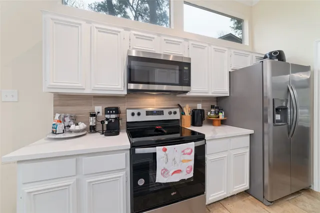 a kitchen with stainless steel appliances a stove a microwave and refrigerator