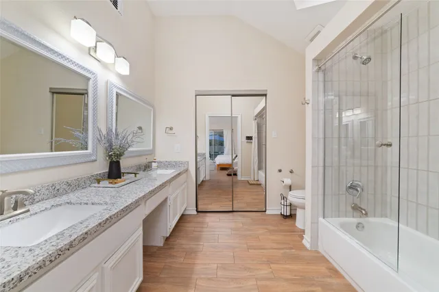 a spacious bathroom with a granite countertop tub sink shower and mirror