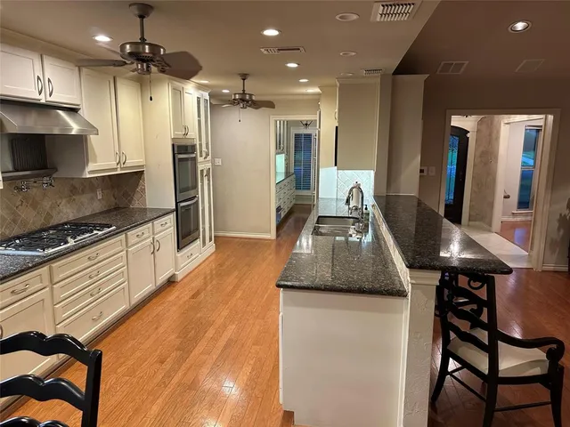 a kitchen with stainless steel appliances granite countertop a sink a stove and a refrigerator