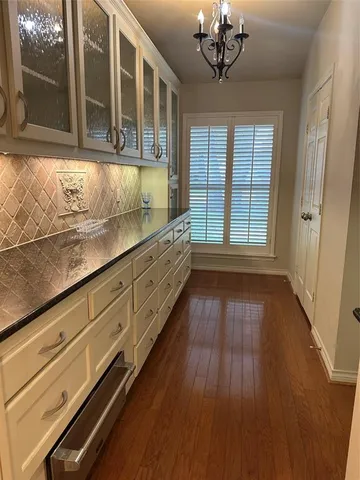 a view of a room with wooden floor and chandelier