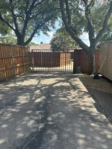 a view of a yard with wooden fence and a large tree