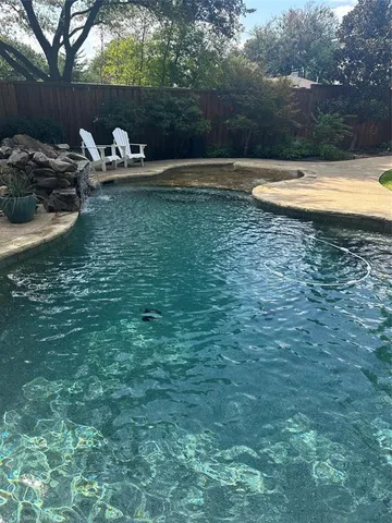 a view of a lake with lawn chairs and a fire pit