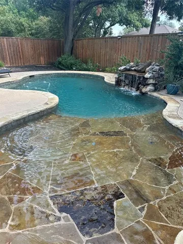 a view of a backyard with chairs potted plants and wooden fence