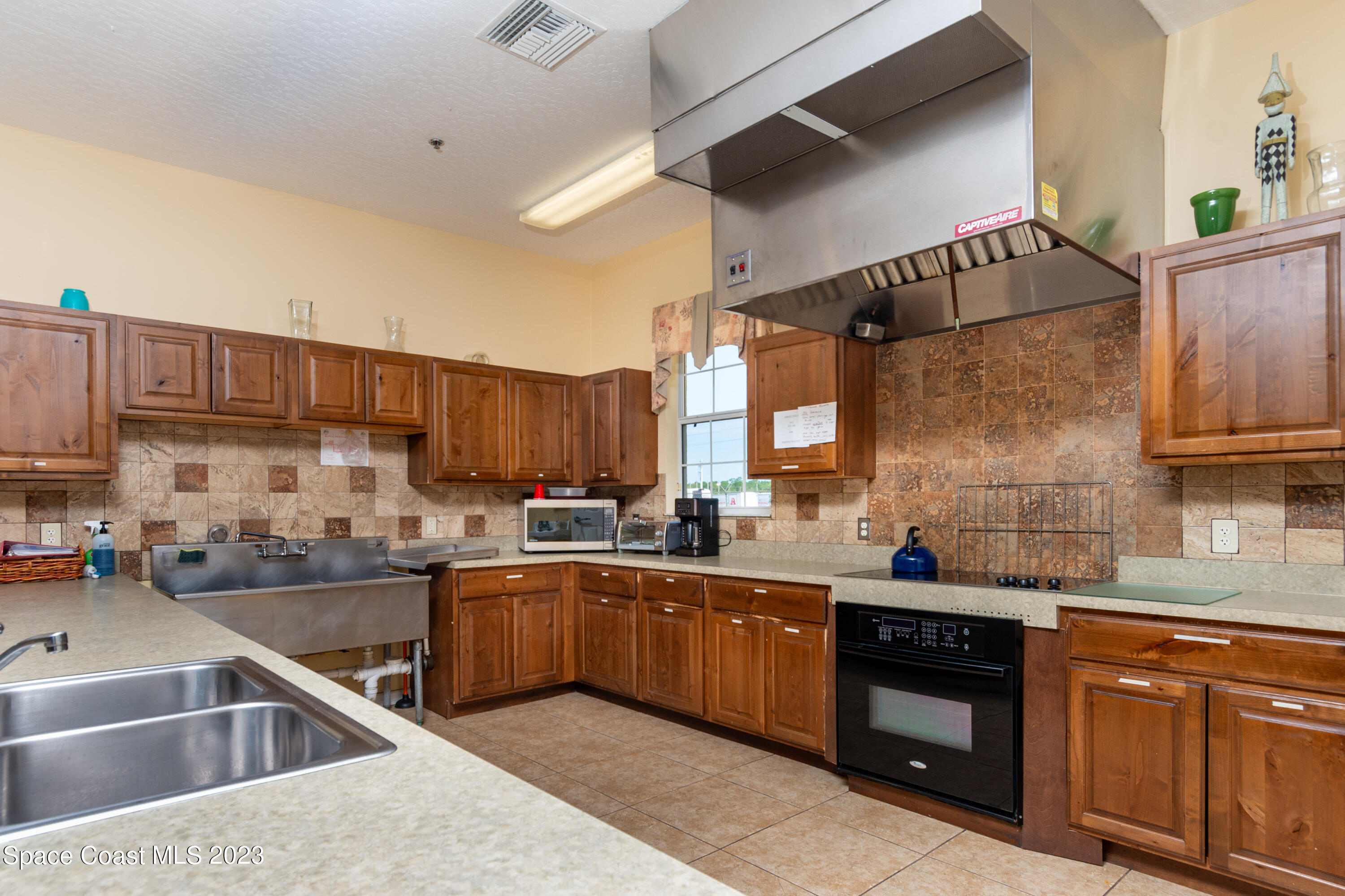 422 Martin Road Palm Bay, FL 32909 - Photo 18 of 37 a kitchen with a sink a stove and cabinets