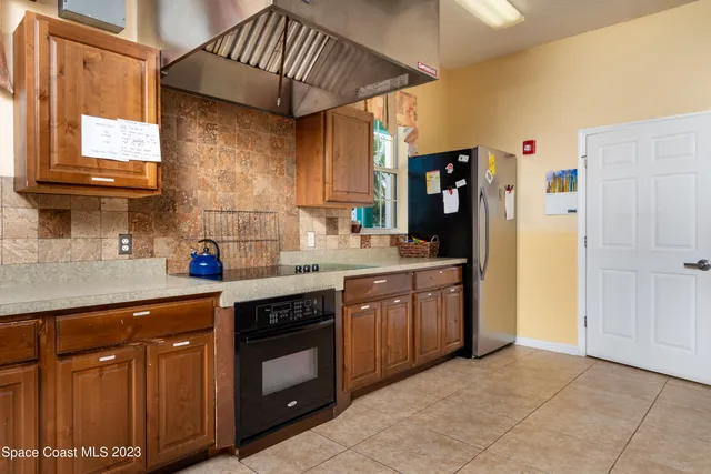 a kitchen with stainless steel appliances granite countertop a refrigerator and a stove top oven