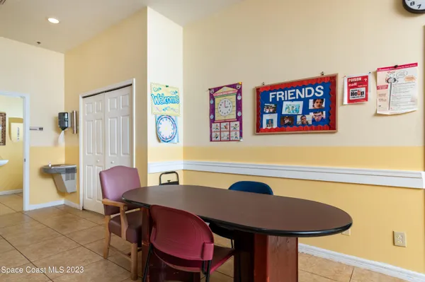 a living room with stainless steel appliances furniture a rug and a kitchen view