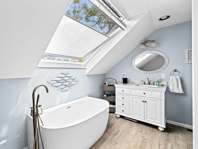 a spacious bathroom with a double vanity sink a mirror and bathtub