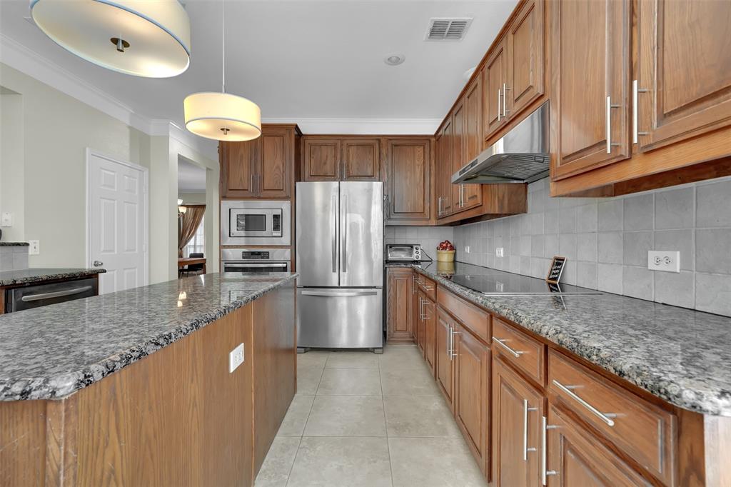 1333 Lighthouse Lane Allen, TX 75013 - Photo 12 of 40 a kitchen with stainless steel appliances granite countertop a sink a stove and a refrigerator