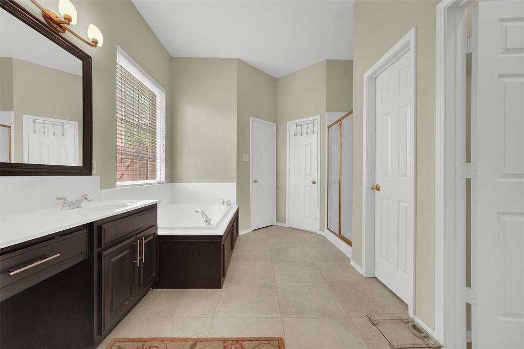 1333 Lighthouse Lane Allen, TX 75013 - Photo 23 of 40 a bathroom with a tub a sink and a large mirror