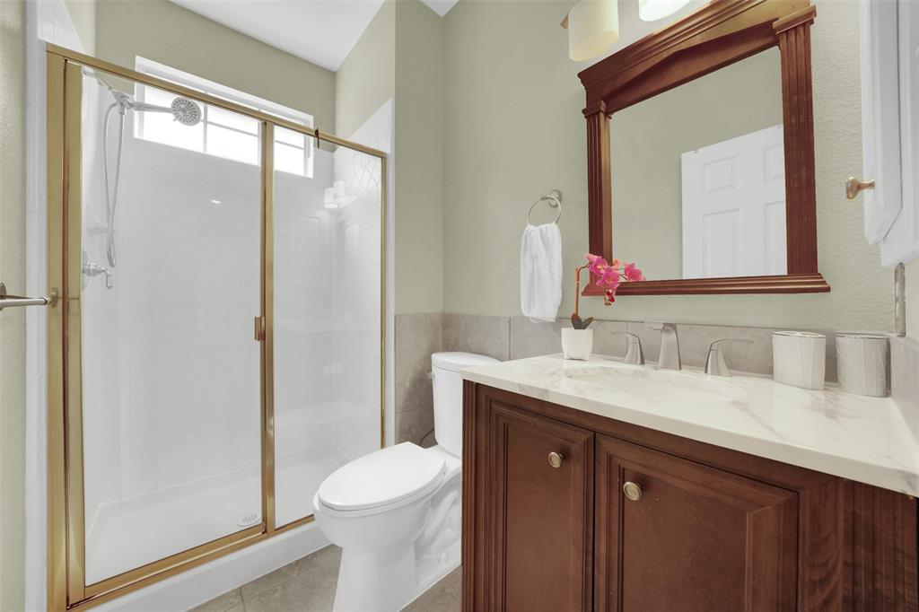 1333 Lighthouse Lane Allen, TX 75013 - Photo 27 of 40 a bathroom with a toilet a sink a vanity and mirror