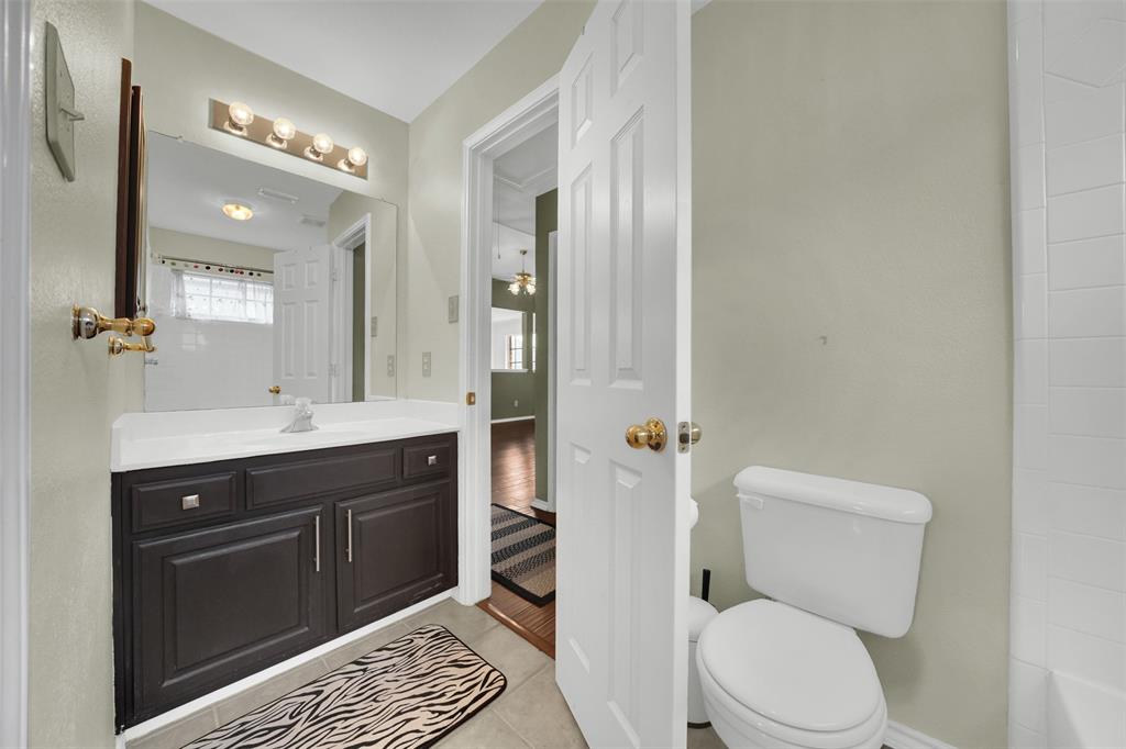 1333 Lighthouse Lane Allen, TX 75013 - Photo 32 of 40 a bathroom with a toilet sink vanity and mirror