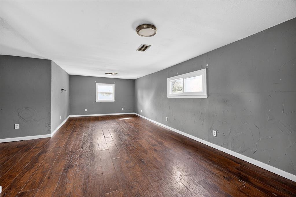 130 Center Street Nevada, TX 75173 - Photo 11 of 32 an empty room with wooden floor and windows
