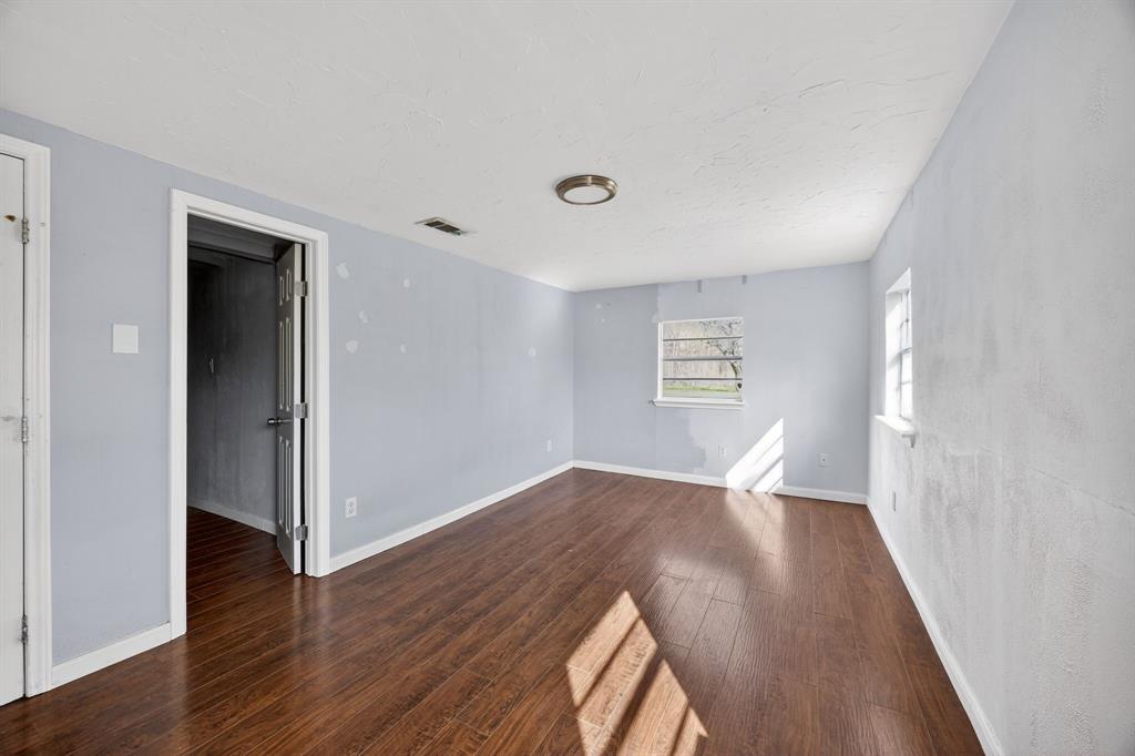 130 Center Street Nevada, TX 75173 - Photo 19 of 32 an empty room with wooden floor and windows