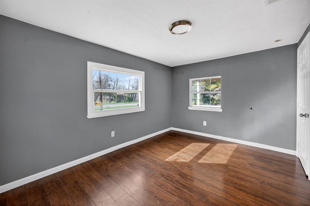 130 Center Street Nevada, TX 75173 - Photo 23 of 32 an empty room with wooden floor and windows