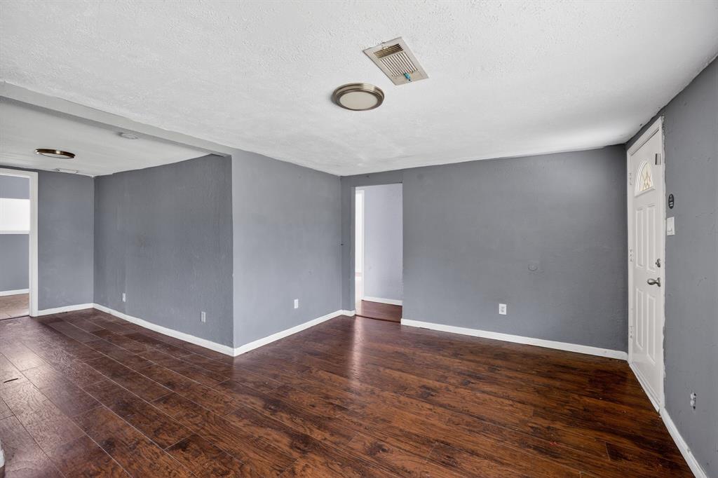 130 Center Street Nevada, TX 75173 - Photo 10 of 32 an empty room with wooden floor and windows