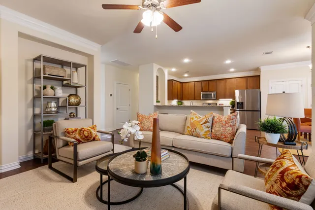 a kitchen with stainless steel appliances granite countertop a stove a refrigerator a sink a dining table and chairs with wooden floor