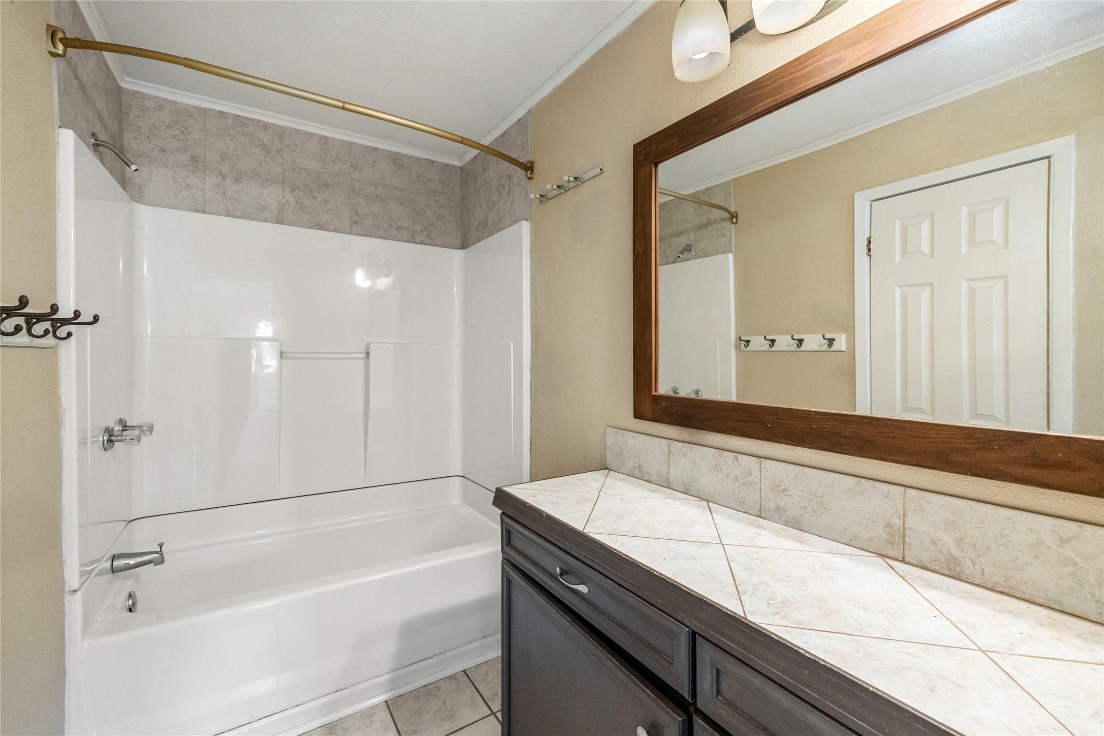 1401 Brazos Street Marble Falls, TX 78654 - Photo 15 of 23 Bathroom with shower / bathtub combination, light tile patterned floors, vanity, and crown molding