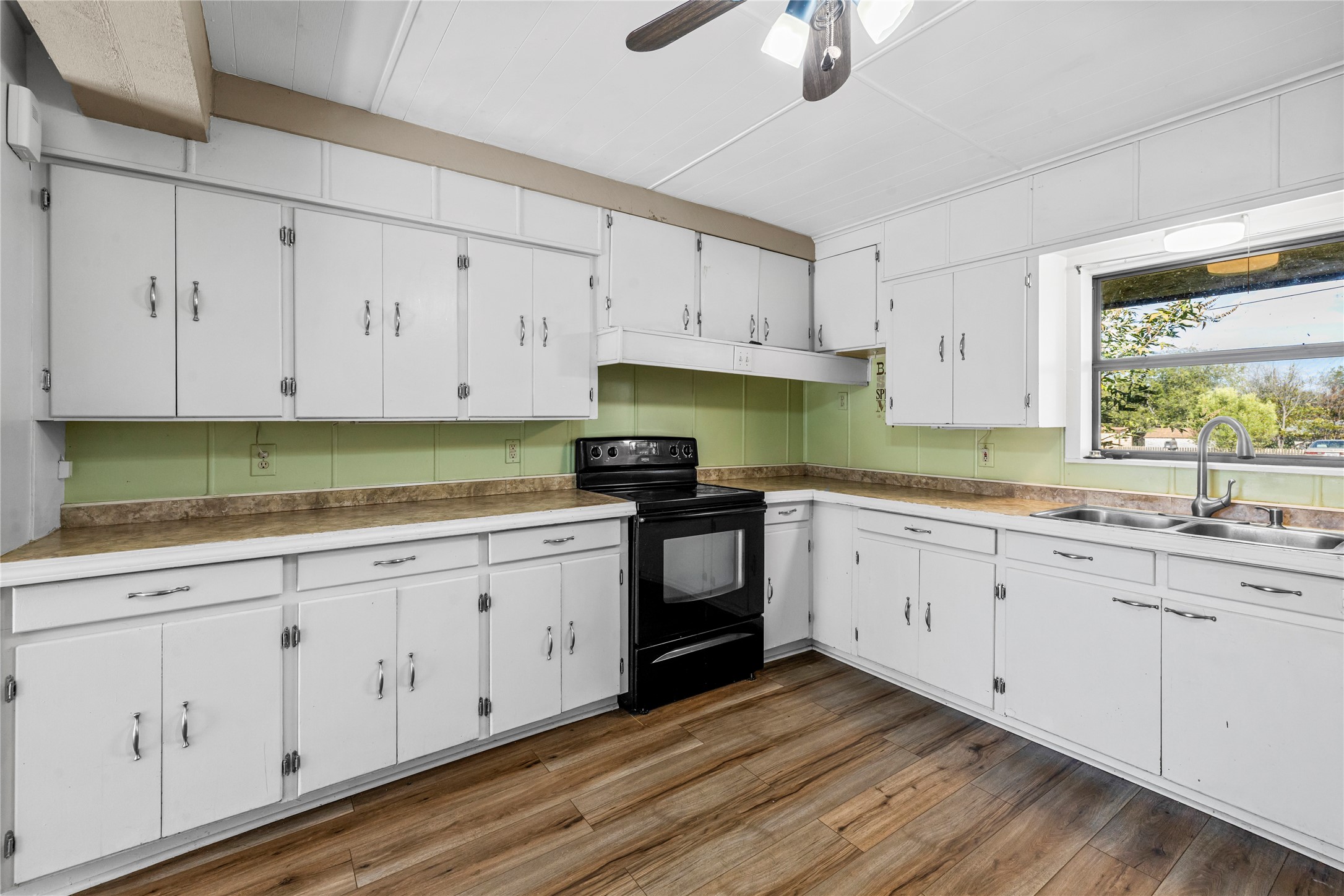 1401 Brazos Street Marble Falls, TX 78654 - Photo 7 of 23 Kitchen featuring white cabinetry, black electric range, dark wood-type flooring, a ceiling fan, and light countertops