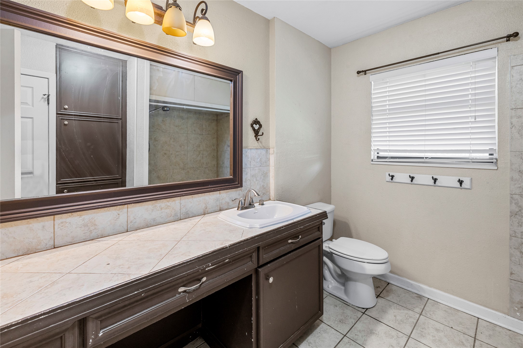 1401 Brazos Street Marble Falls, TX 78654 - Photo 10 of 23 Bathroom featuring light tile patterned floors, vanity, and a shower