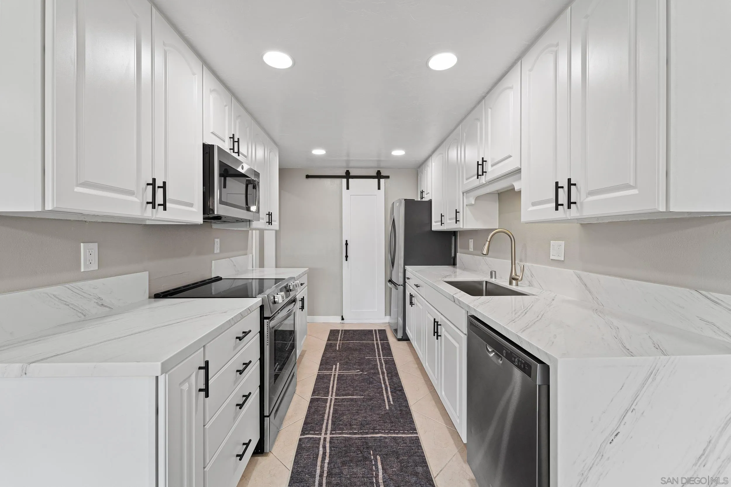 12424 Rios Road San Diego, CA 92128 - Photo 15 of 35 a kitchen with a sink stove and cabinets