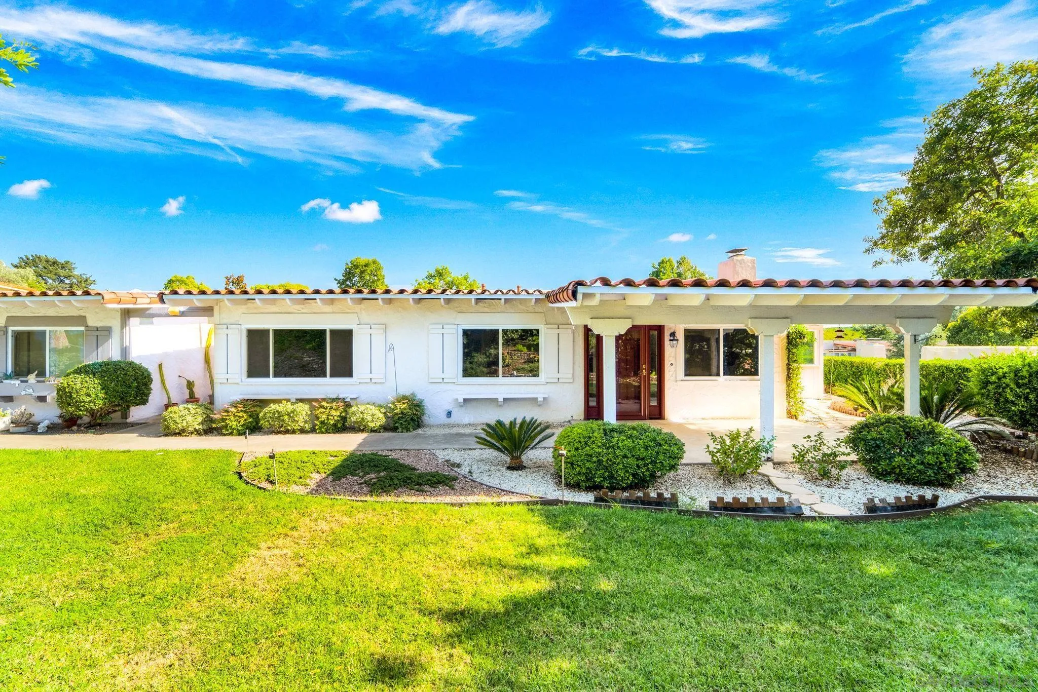 12424 Rios Road San Diego, CA 92128 - Photo 2 of 35 a view of a white house with a big yard and potted plants