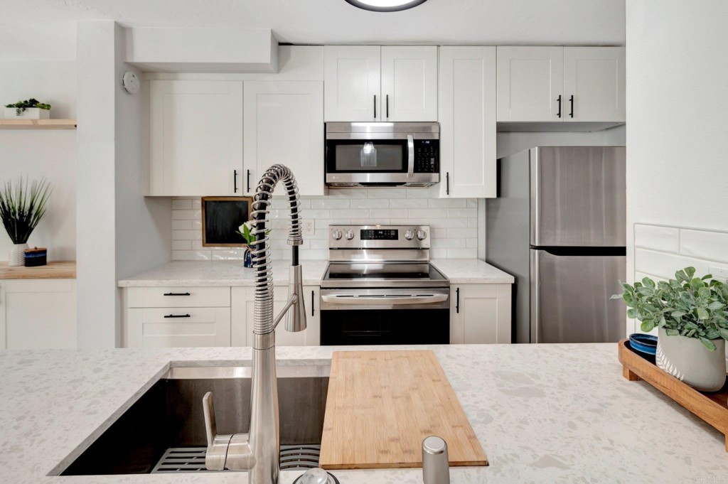 9932 Mission Vega Road, Unit 2 Santee, CA 92071 - Photo 11 of 28 a kitchen with granite countertop a refrigerator stove and microwave