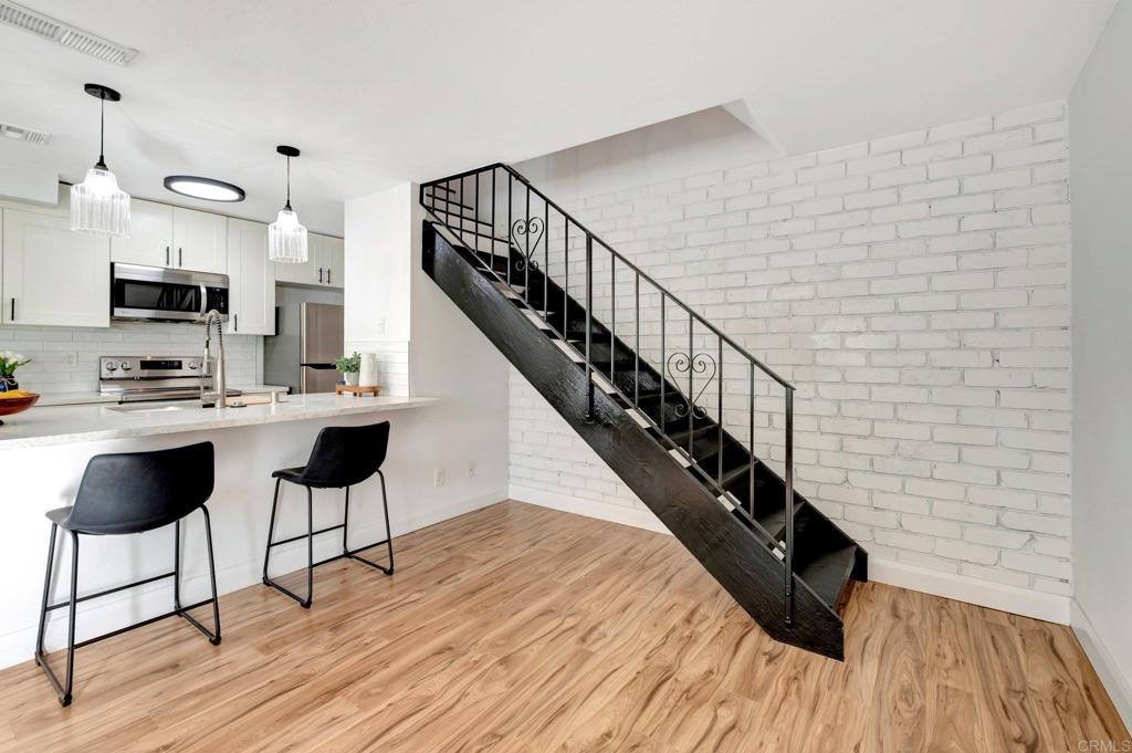 9932 Mission Vega Road, Unit 2 Santee, CA 92071 - Photo 12 of 28 a dining room with wooden floor and a chandelier