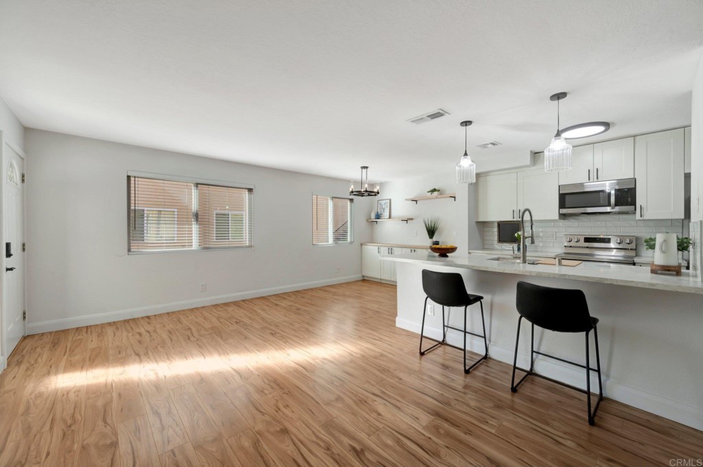 9932 Mission Vega Road, Unit 2 Santee, CA 92071 - Photo 2 of 28 a kitchen with stainless steel appliances kitchen island wooden floors and view living room