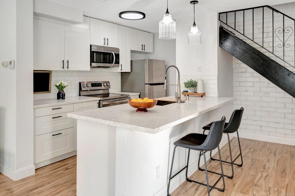 9932 Mission Vega Road, Unit 2 Santee, CA 92071 - Photo 4 of 28 a kitchen with a table chairs microwave and cabinets