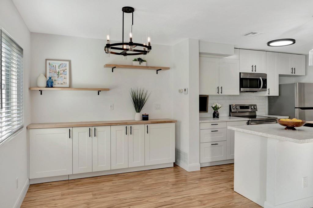 9932 Mission Vega Road, Unit 2 Santee, CA 92071 - Photo 6 of 28 a kitchen with white cabinets and stainless steel appliances