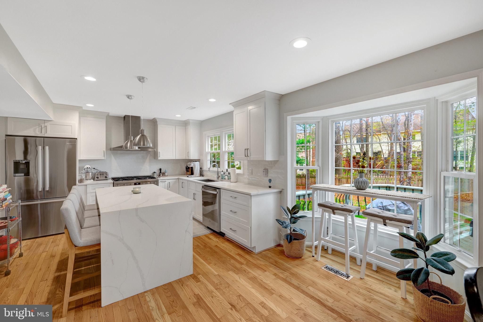 44116 Bristow Circle Ashburn, VA 20147 - Photo 22 of 79 a large white kitchen with lots of counter top space and stainless steel appliances