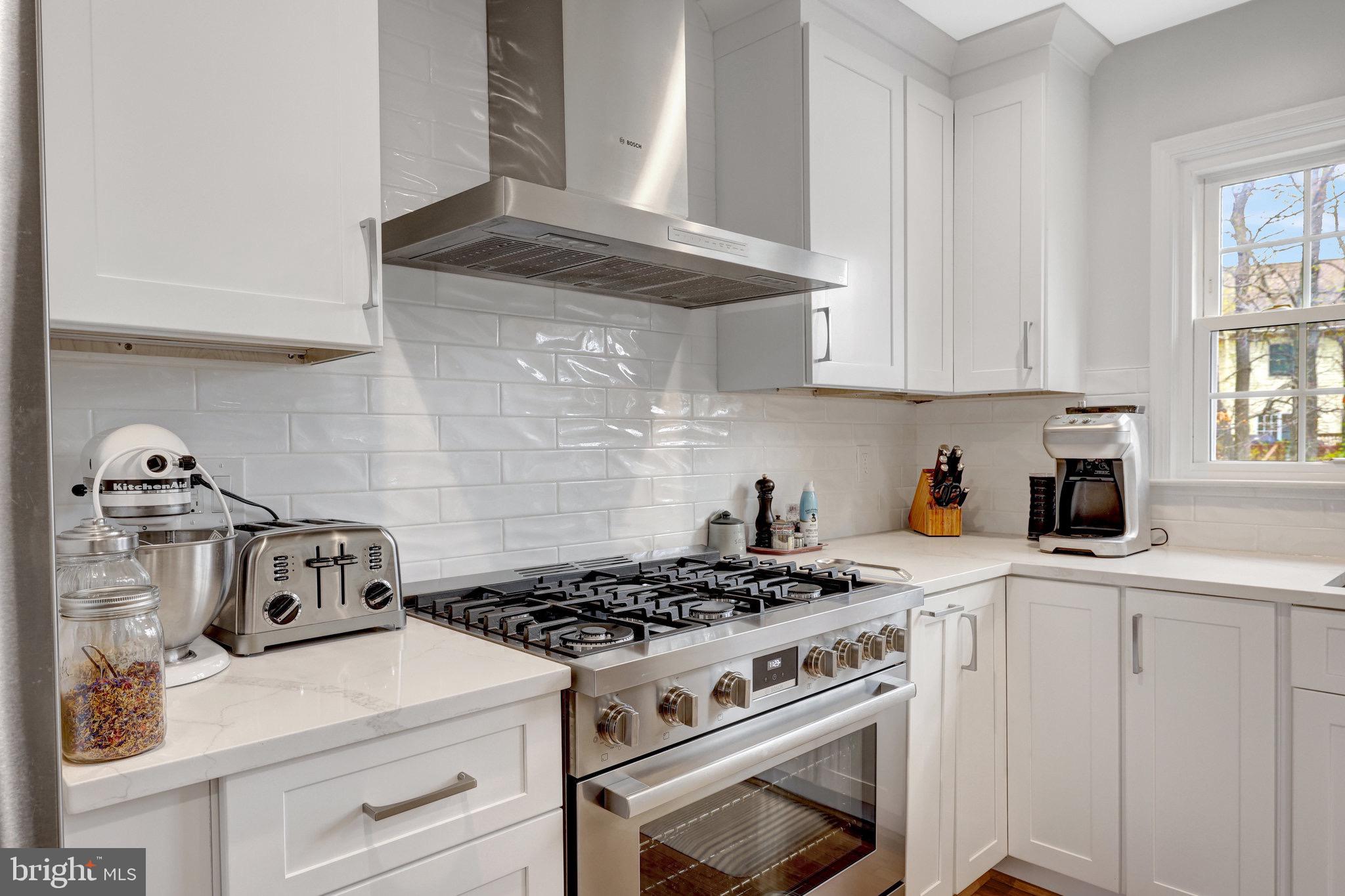 44116 Bristow Circle Ashburn, VA 20147 - Photo 26 of 79 a kitchen with a stove and white cabinets