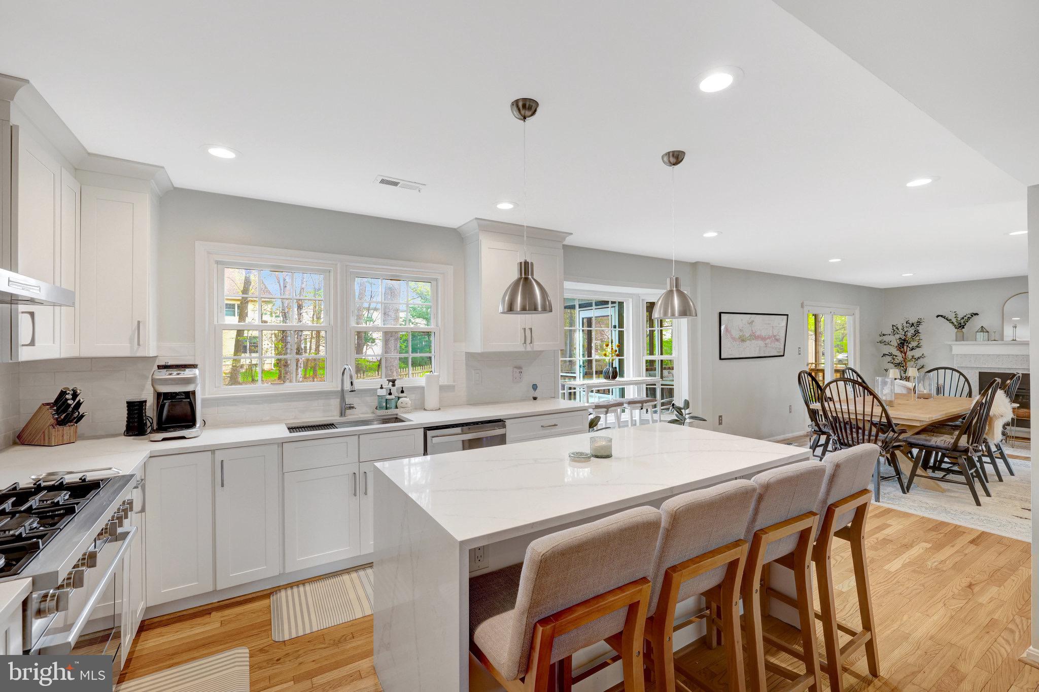 44116 Bristow Circle Ashburn, VA 20147 - Photo 28 of 79 a kitchen with a dining table chairs and white cabinets