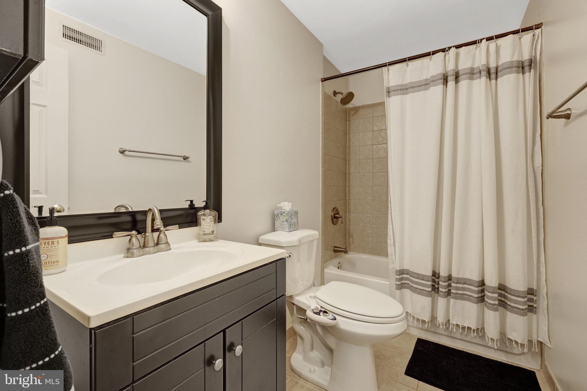 44116 Bristow Circle Ashburn, VA 20147 - Photo 63 of 79 a bathroom with a sink a toilet a mirror and shower curtain