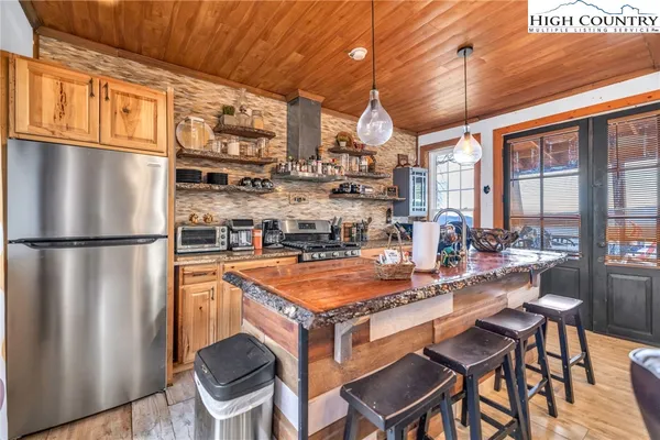 a kitchen with stainless steel appliances granite countertop a stove a sink and a wooden cabinets