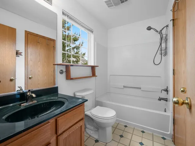 a bathroom with a granite countertop sink toilet and shower