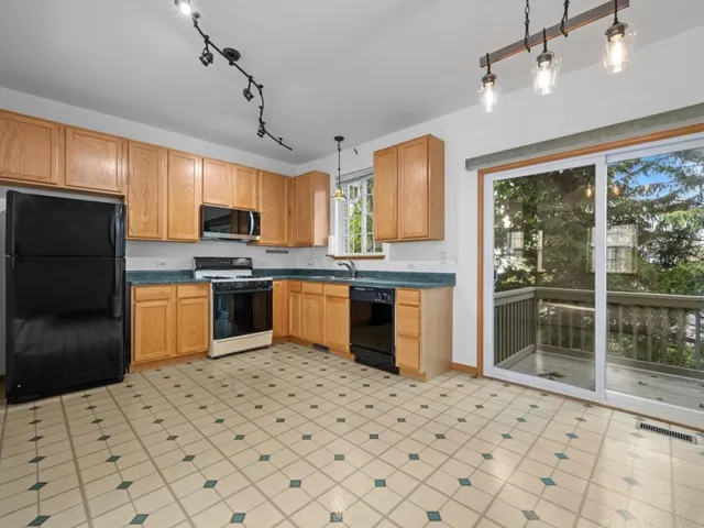 a kitchen with stainless steel appliances a stove top oven a sink dishwasher a refrigerator and a cabinets