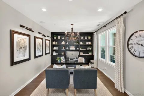 a dining room with furniture potted plants and wooden floor