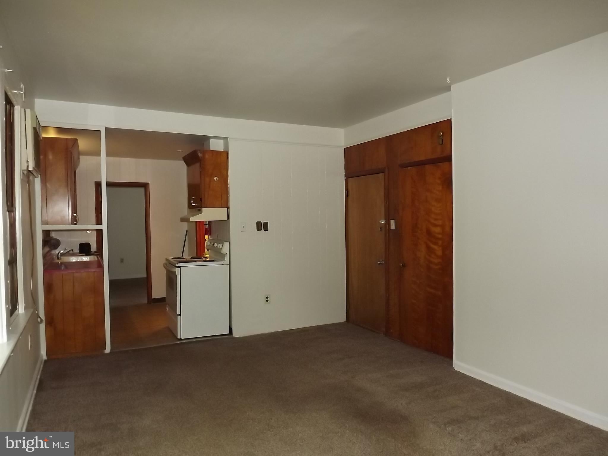 an empty room with closet and wooden door