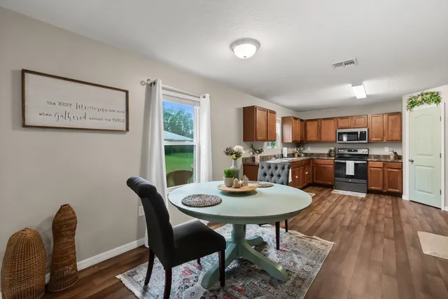 a view of a white house with a big yard and large trees