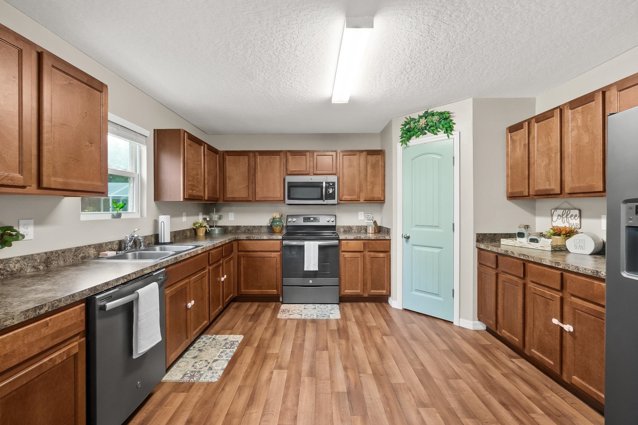 10 Pickcane Lane Palm Coast, FL 32164 - Photo 15 of 43 a kitchen with stainless steel appliances granite countertop wooden cabinets a stove top oven a sink and dishwasher with wooden floor
