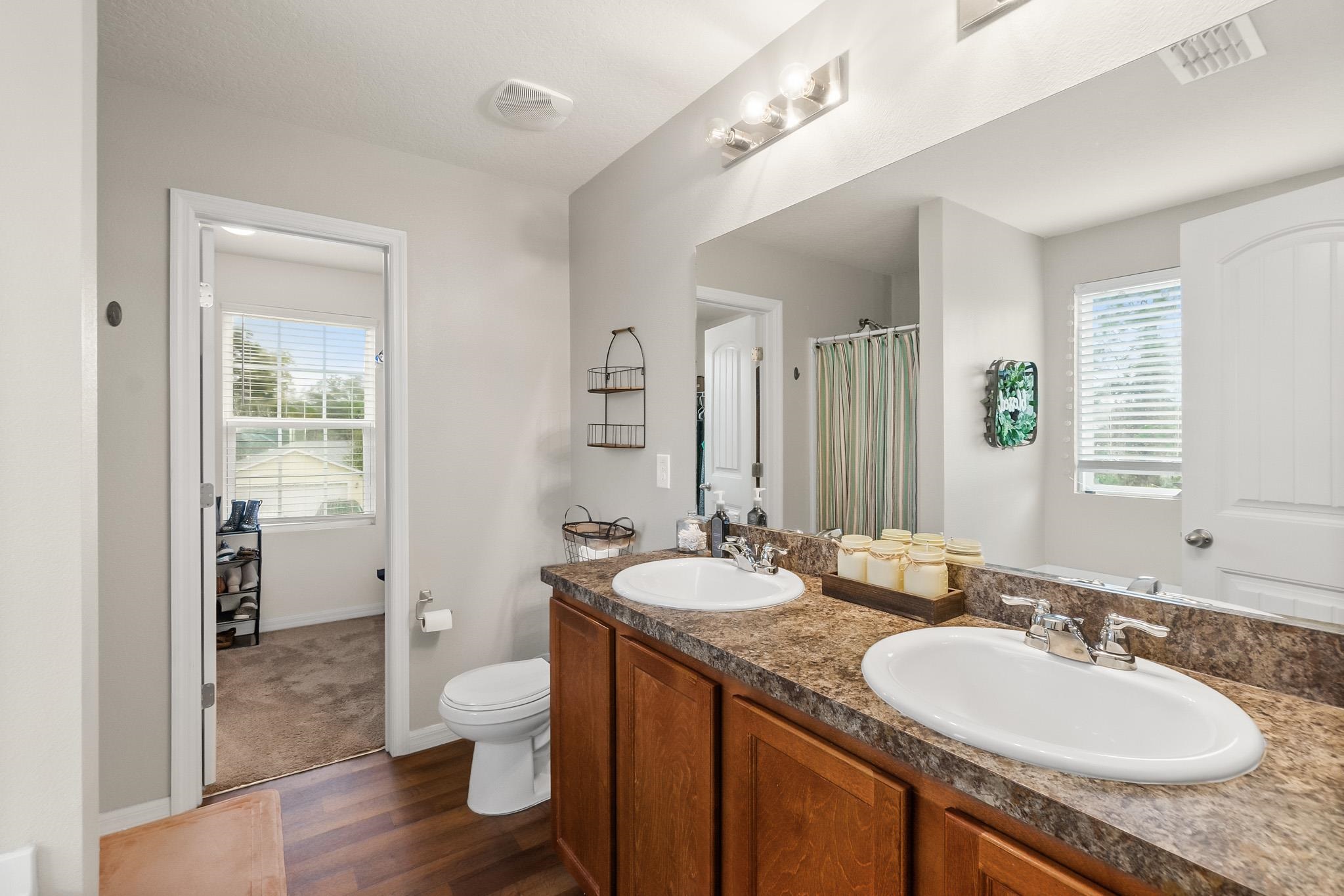 10 Pickcane Lane Palm Coast, FL 32164 - Photo 27 of 43 a bathroom with a granite countertop double vanity sinks a mirror and a toilet