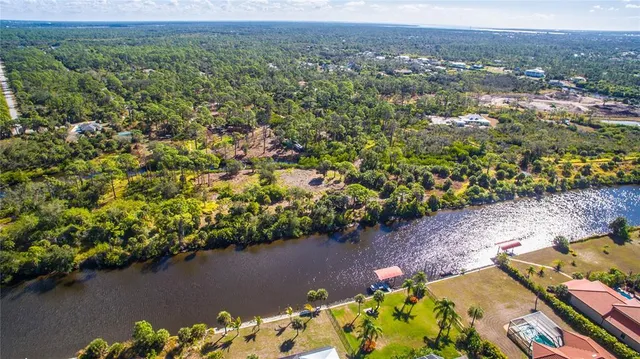an aerial view of a house with a yard and lake view