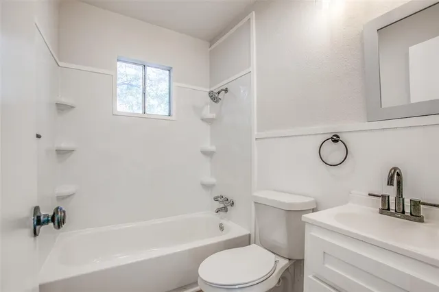 a bathroom with a toilet sink vanity tub and shower