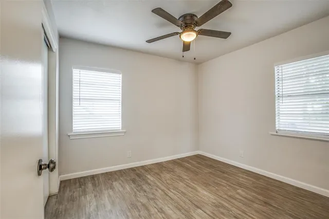 an empty room with a window and a fan