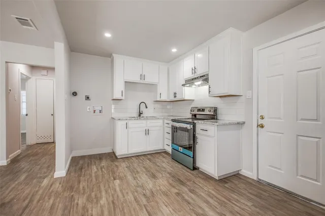 a kitchen with granite countertop white cabinets and white appliances