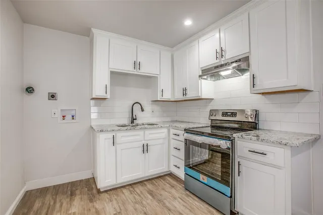a kitchen with cabinets stainless steel appliances and wooden floor