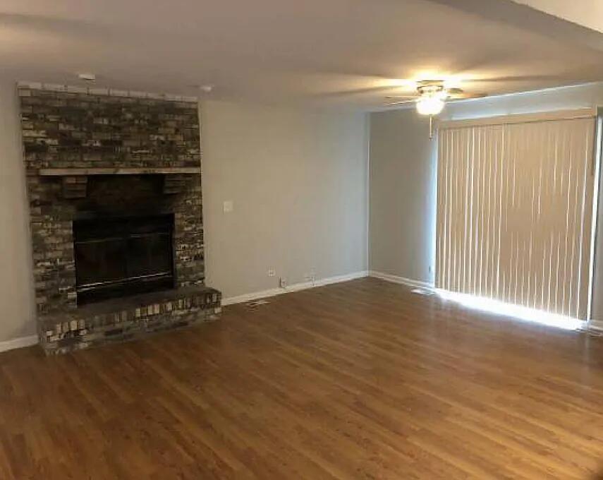 5631 Colgate Lane Matteson, IL 60443 - Photo 2 of 8 an empty room with wooden floor fireplace and windows