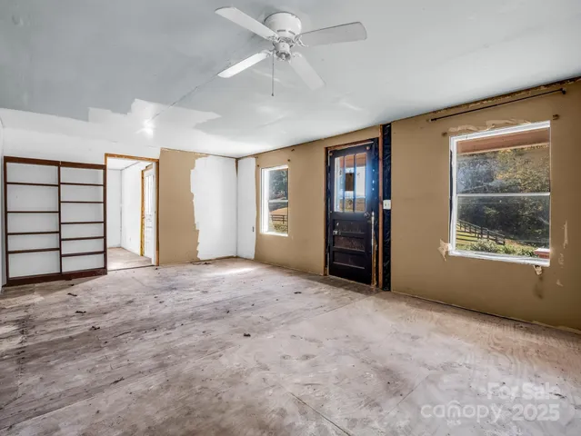 an empty room with windows and closet