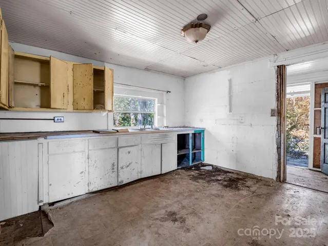 a kitchen with granite countertop cabinets stainless steel appliances a sink and a large window